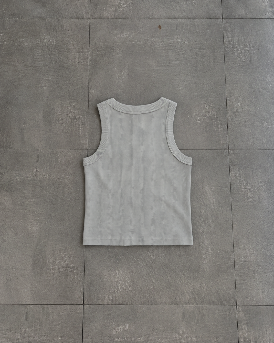 A light gray ribbed tank top laid flat on a gray tiled floor.

Color: Storm Back
