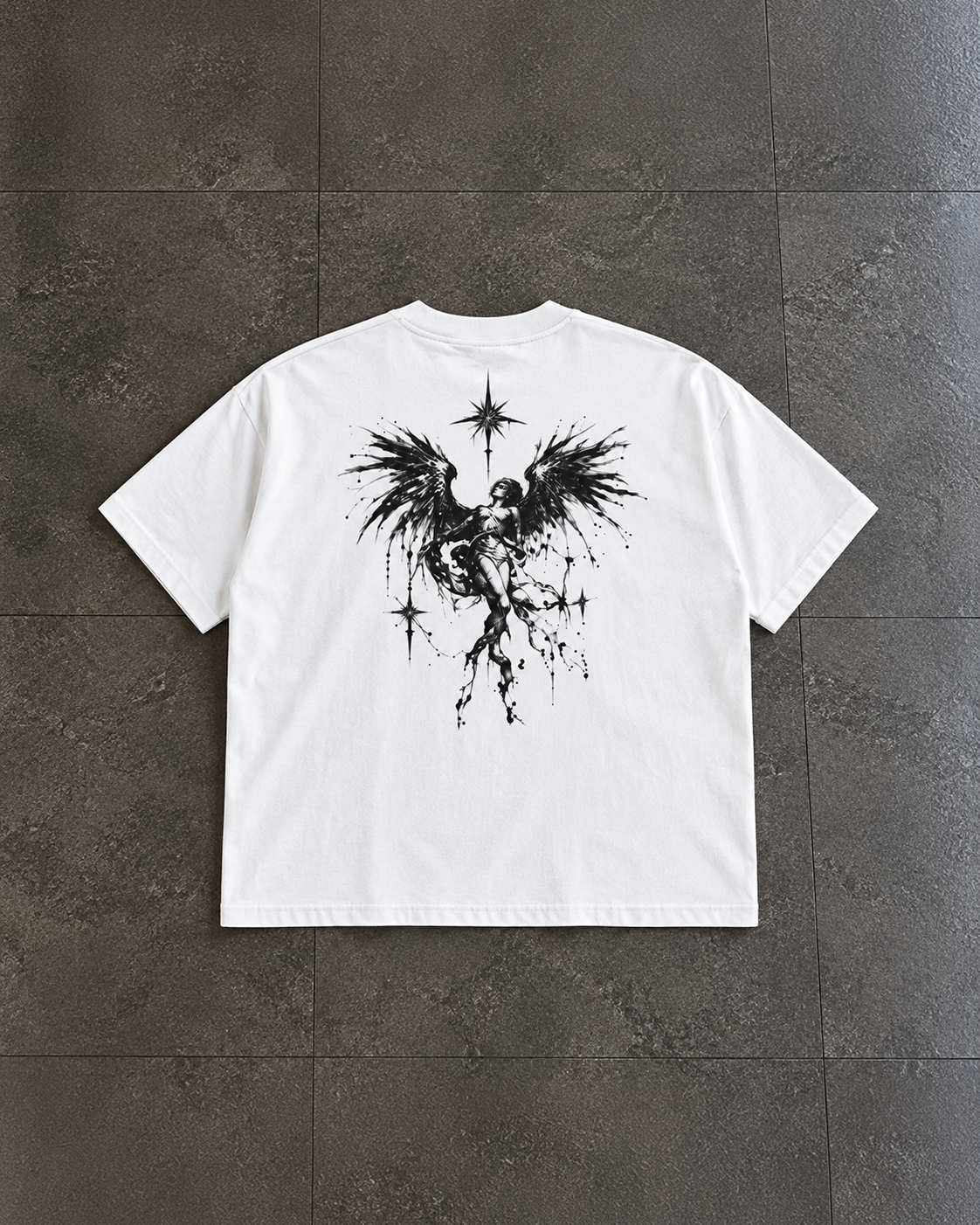 A white short-sleeve t-shirt laid flat on dark gray tiled flooring, featuring a large black graphic print of a winged figure with stars on the back.