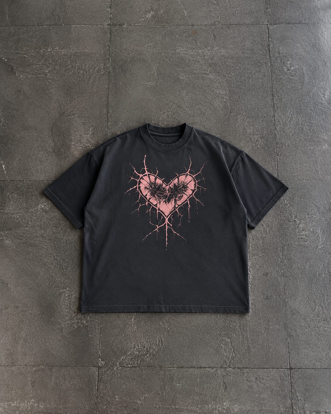 A black short-sleeve t-shirt with a pink splattered heart graphic containing a black bat silhouette, laid flat on a dark gray stone-tiled surface.

Color: Black Front 