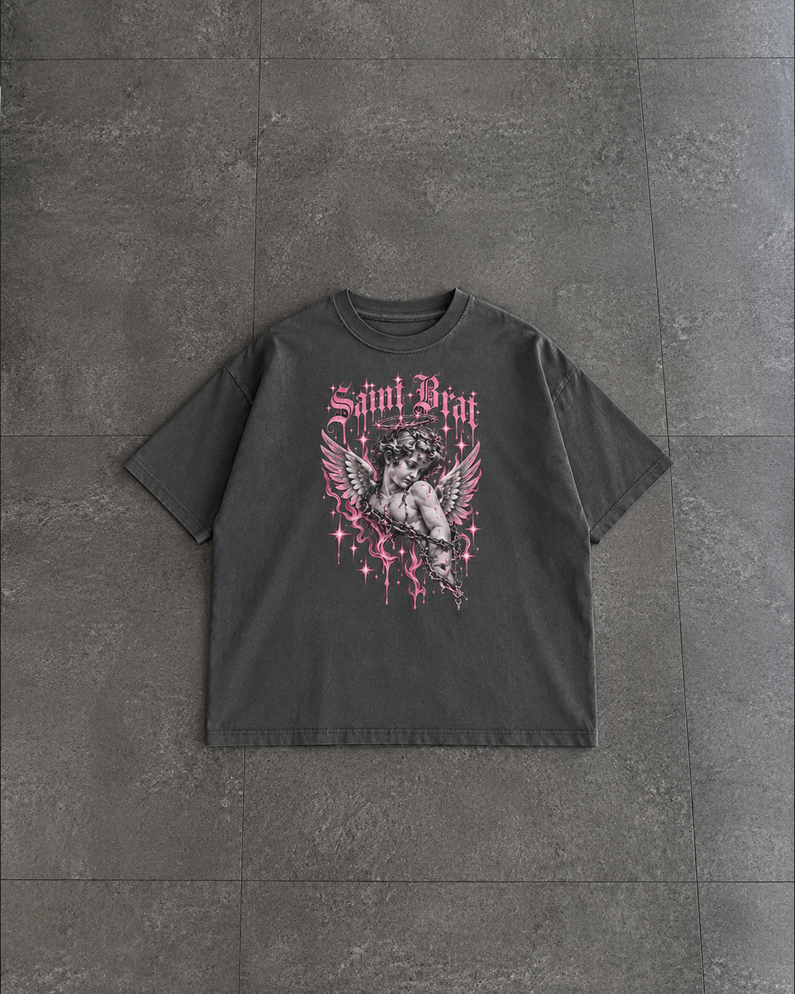 A dark gray washed graphic t-shirt featuring a pink and black Saint Brath design, laid flat on a dark gray tiled floor.

Color: Pepper Front