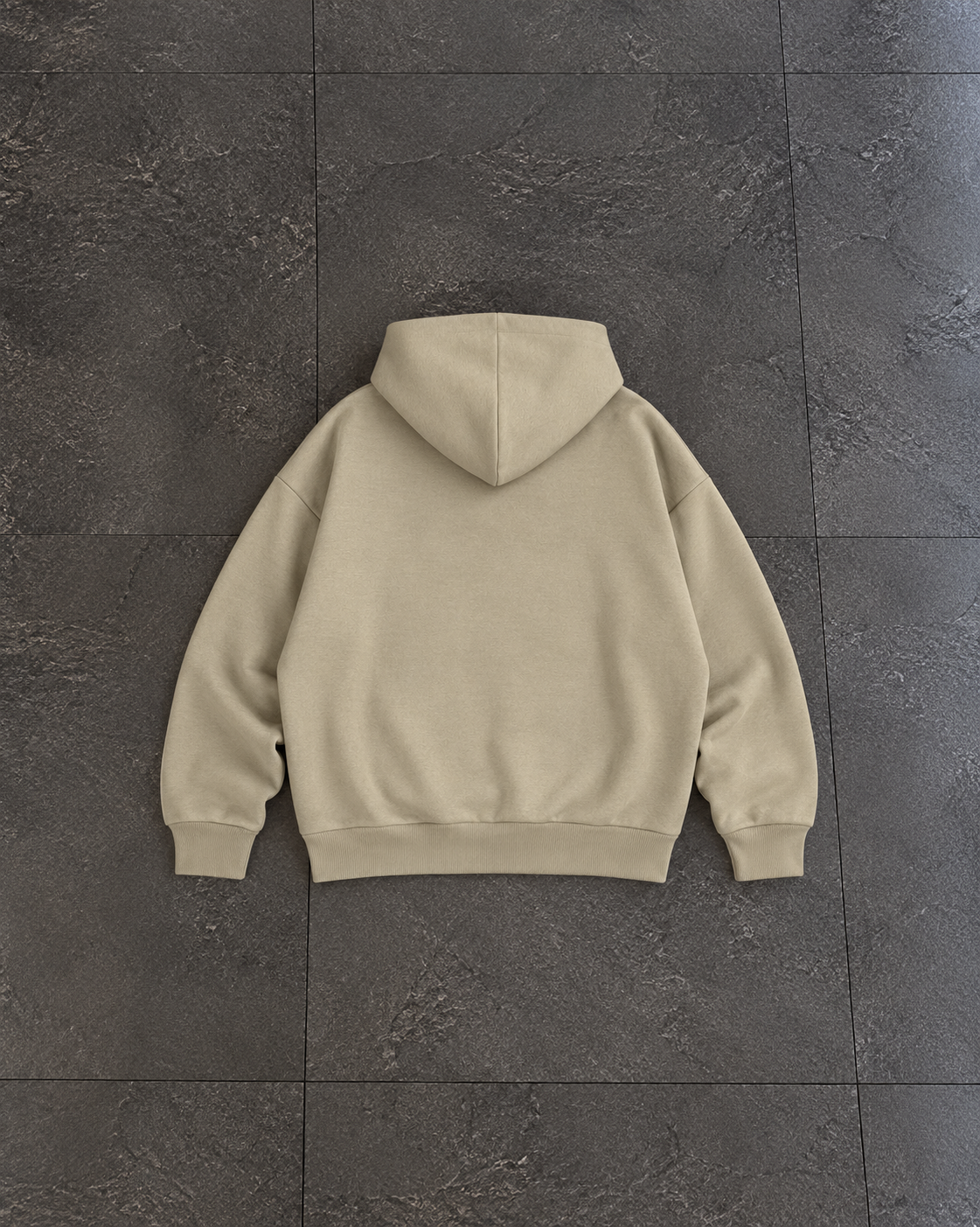 A light beige pullover hoodie shown from the back, laid flat on a dark gray tiled floor.

Color: Stone Back