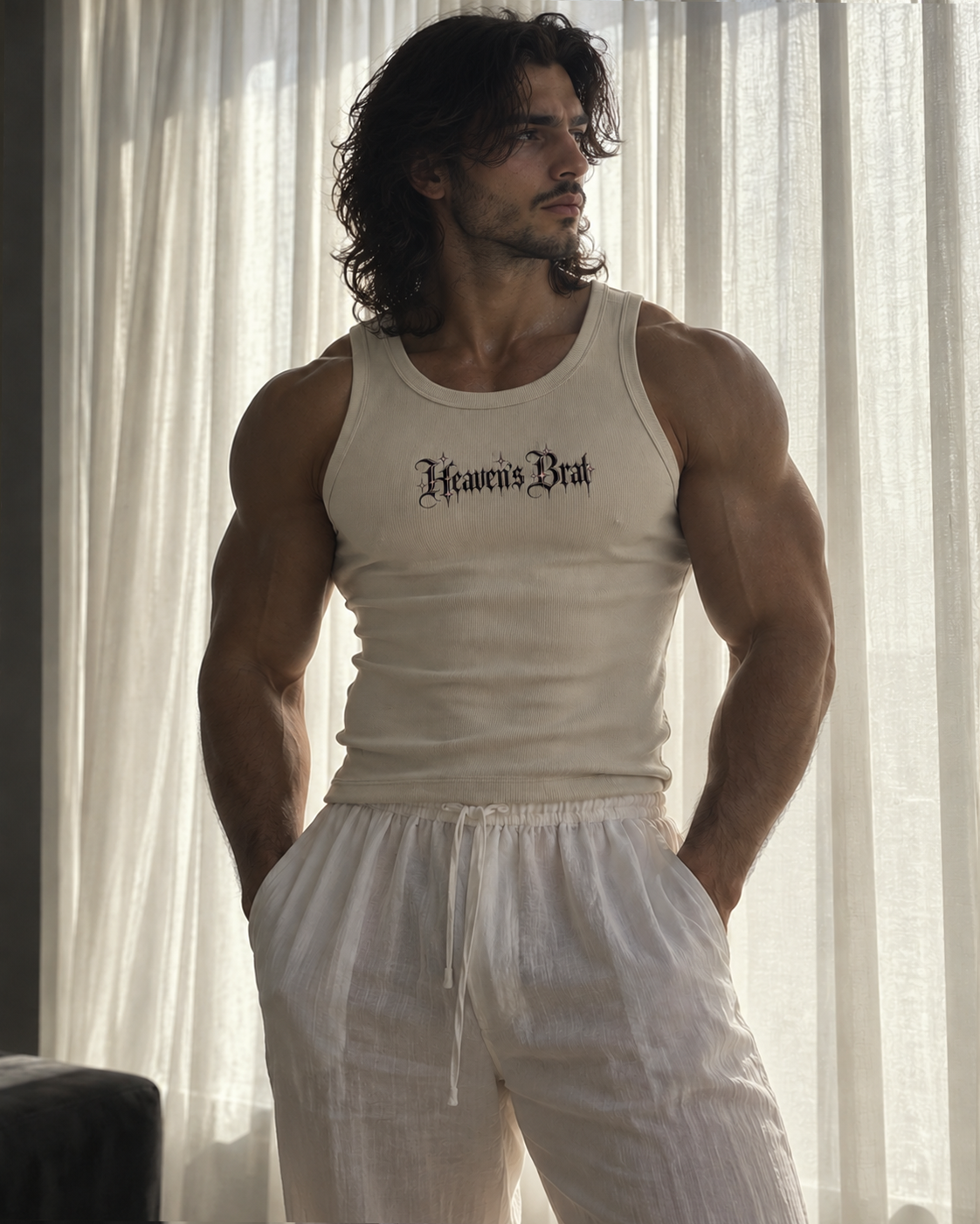A muscular man with long dark hair stands in front of sheer white curtains, wearing a fitted off-white tank top with the text 'Heaven's Breath' in a black gothic font across the chest, paired with loose off-white drawstring shorts.

Color: Bone Front