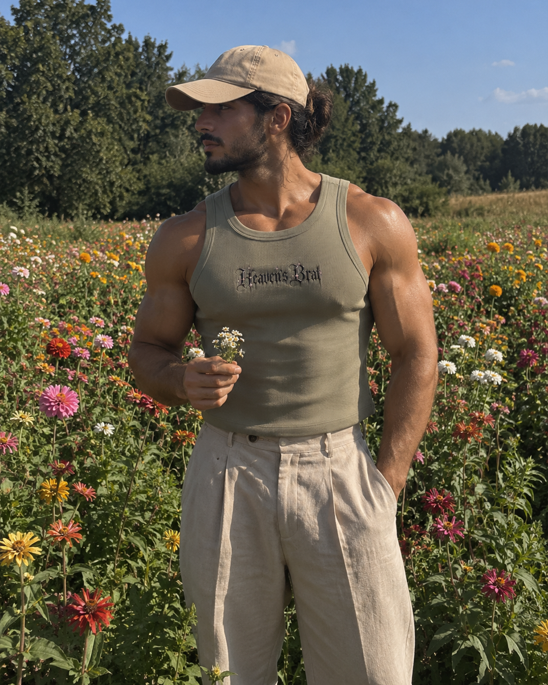 A man standing in a colorful wildflower field wearing a beige baseball cap, a sage green tank top with 'Falcone Red' printed on the chest, and light beige linen trousers.

Color: Eucalyptus Front