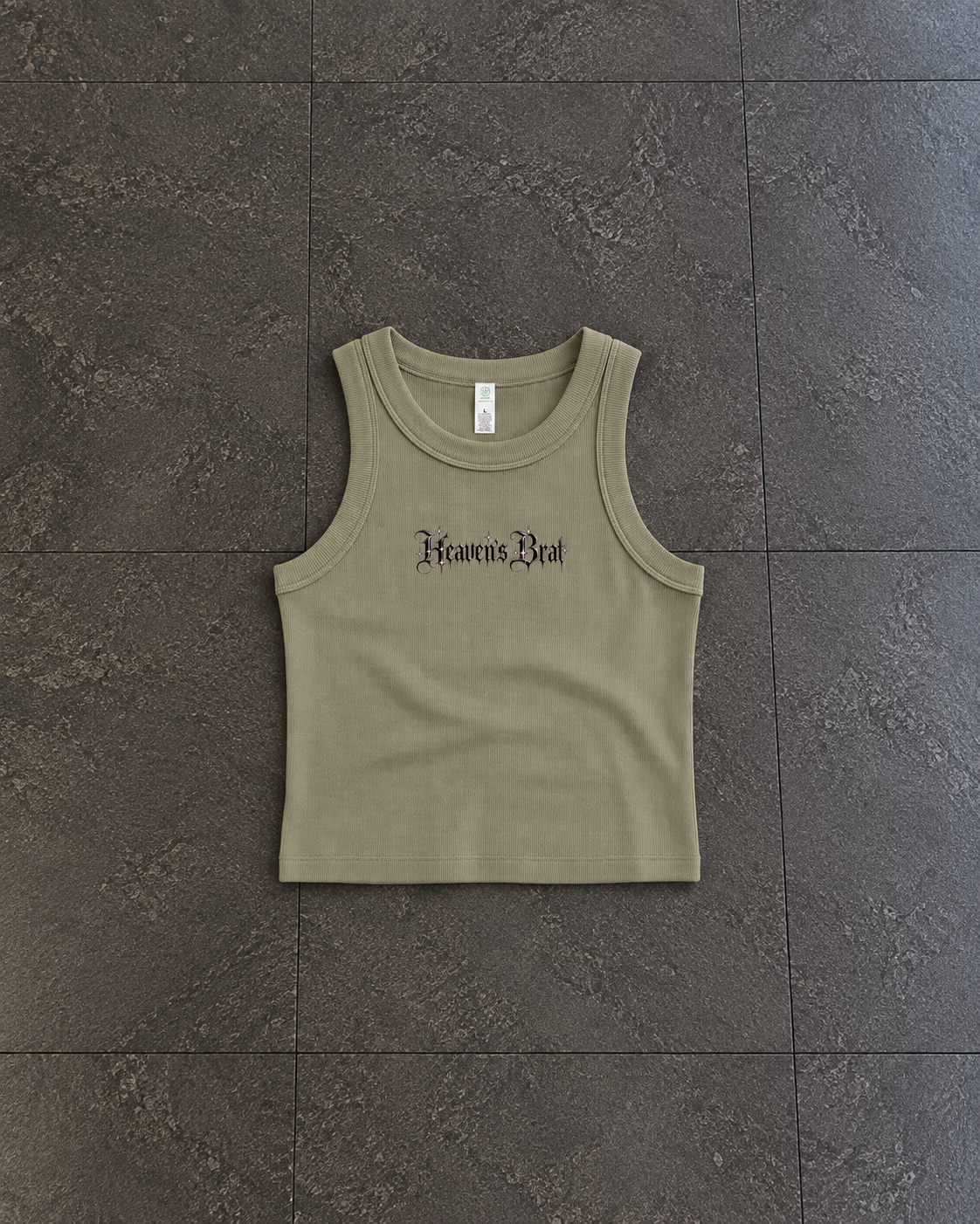 An olive green ribbed tank top with 'Kreatus Dei' printed in black gothic font across the chest, laid flat on a dark gray tiled floor.

Color: Eucalyptus Front